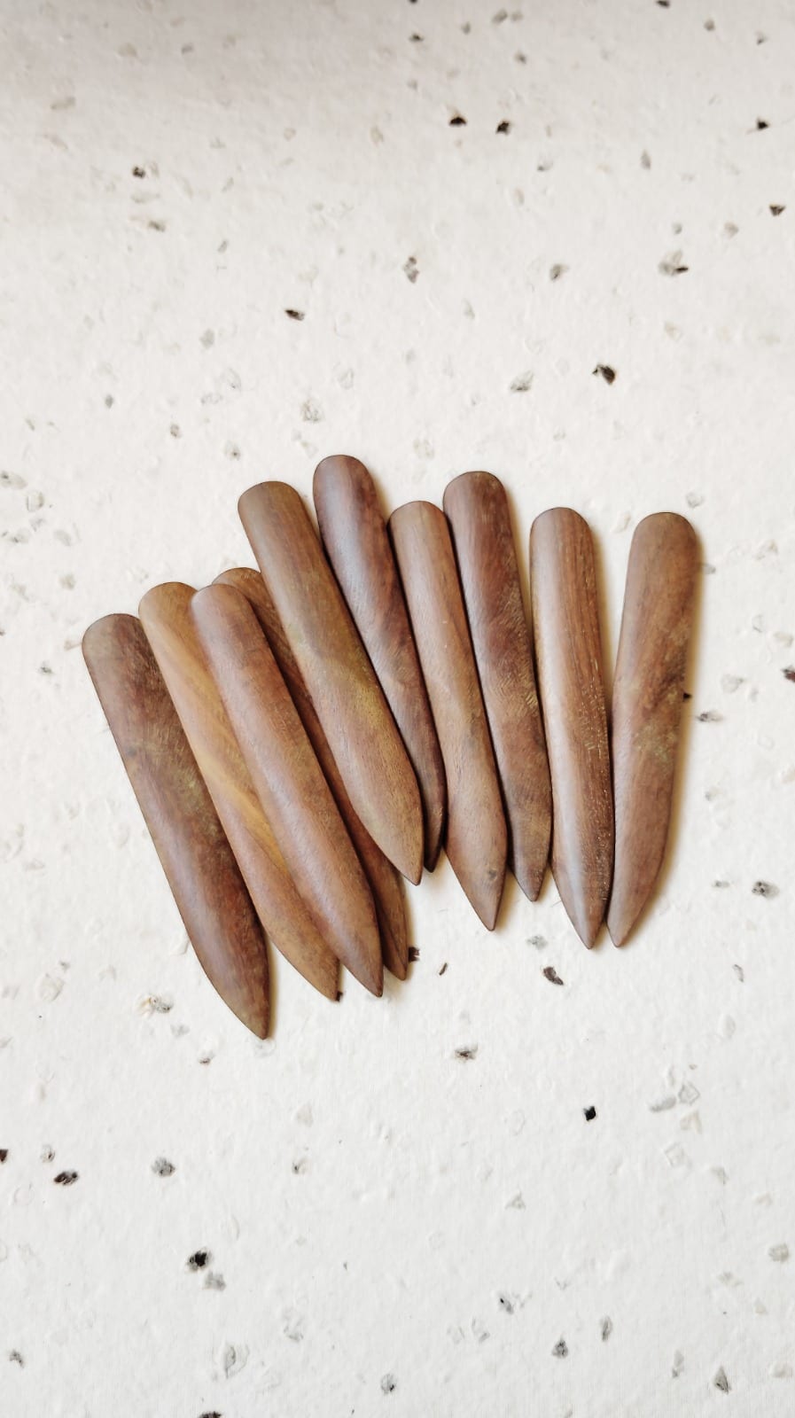 Collection of weathered walnut bone folders for bookbinding, overhead view