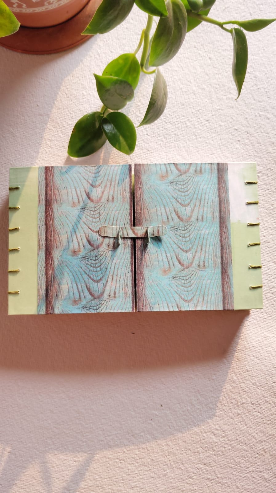 Coptic journal spine detail — exposed waxed-linen stitching on a marbled-paper cover