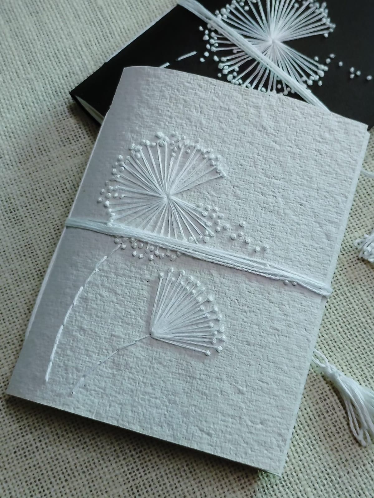 Coptic-stitched A4 sketchbook spine detail showing waxed-linen binding