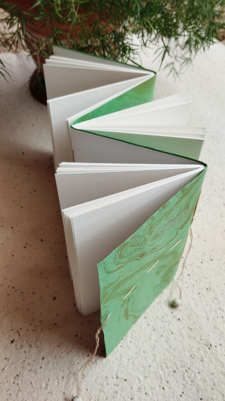 Green-marbled Japanese stab-bound notebook opened to show concertina-folded interior