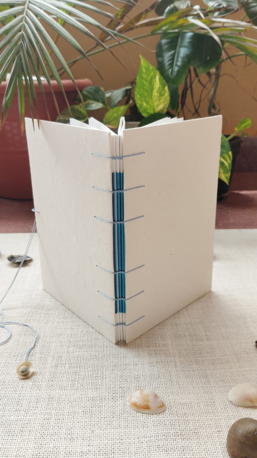 Stack of A7 pocket zines showing mixed handmade paper covers