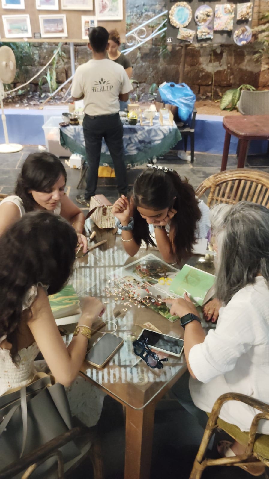 Adults crafting Coptic-bound journals at a Spread & Spine bookbinding workshop in India