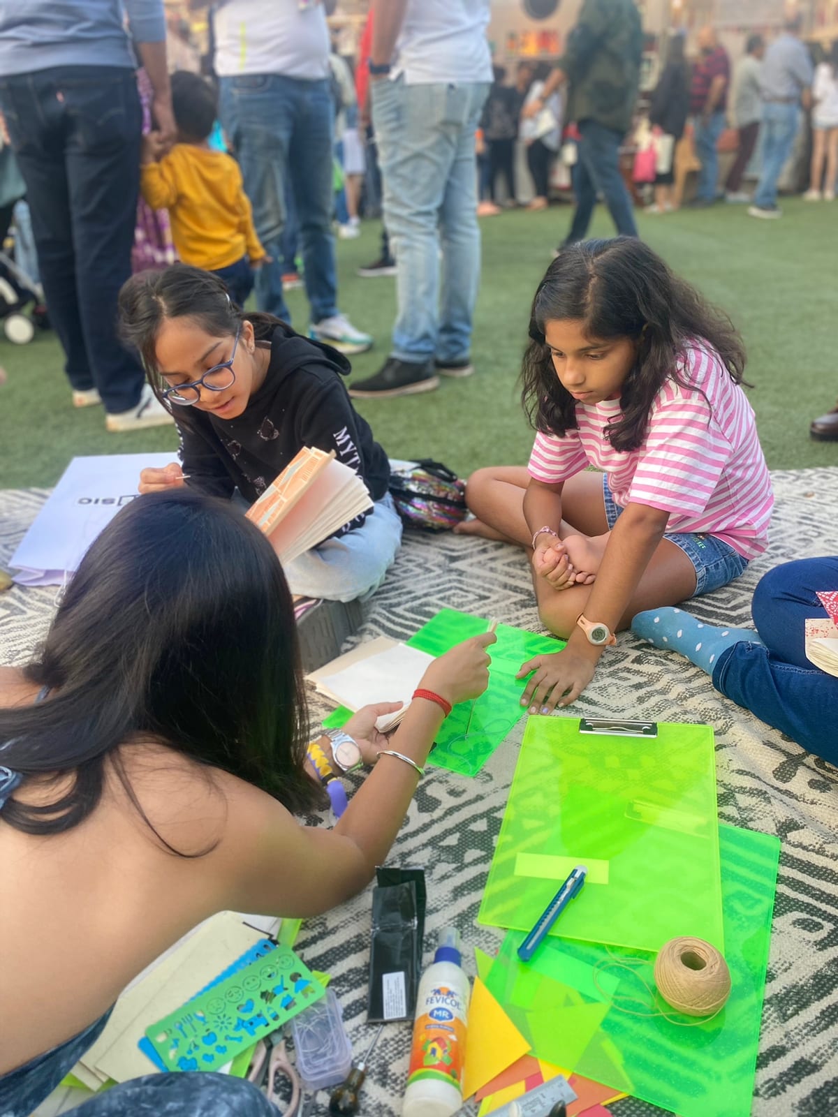 Children making their first hand-bound books at an outdoor Spread & Spine summer club session